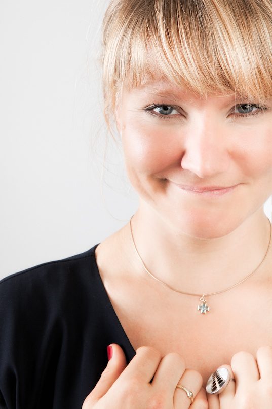 Judith, cyclist, holding a dress with jewellery, studio portrait by Mat Smith Photography, London
