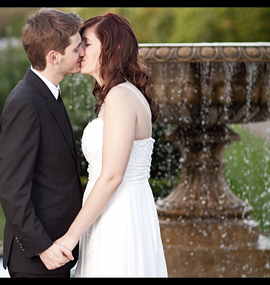 Wedding couple kissing by a fountain, Regent's Park, London