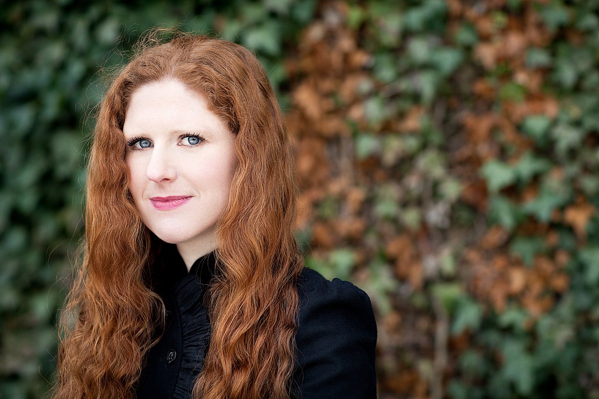 Composer Cheryl Frances-Hoad, auburn curly hair against autumn ivy