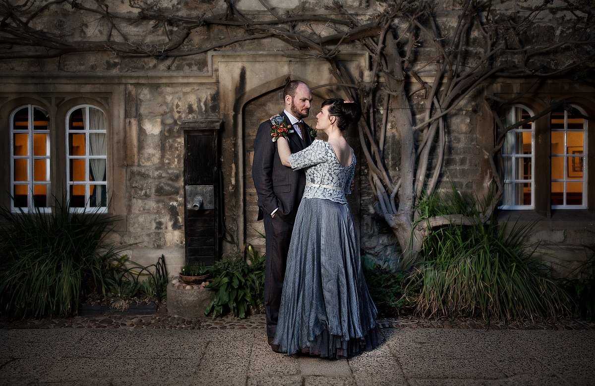 Couple embracing under wisteria, moody atmospheric portrait