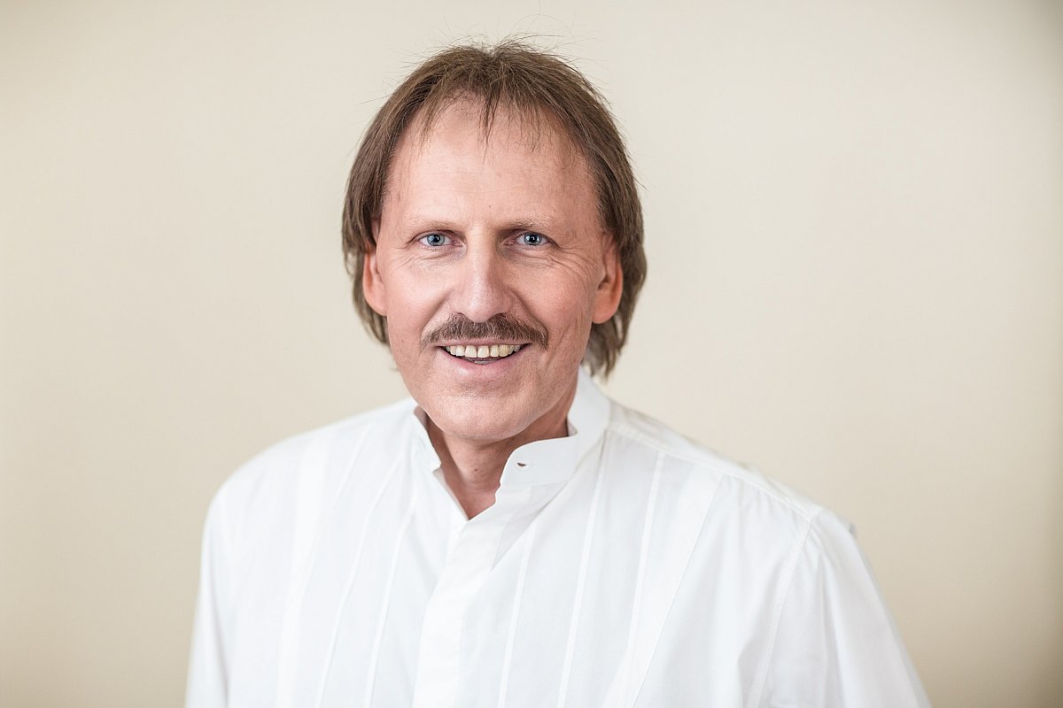 Headshot of a man in a white shirt