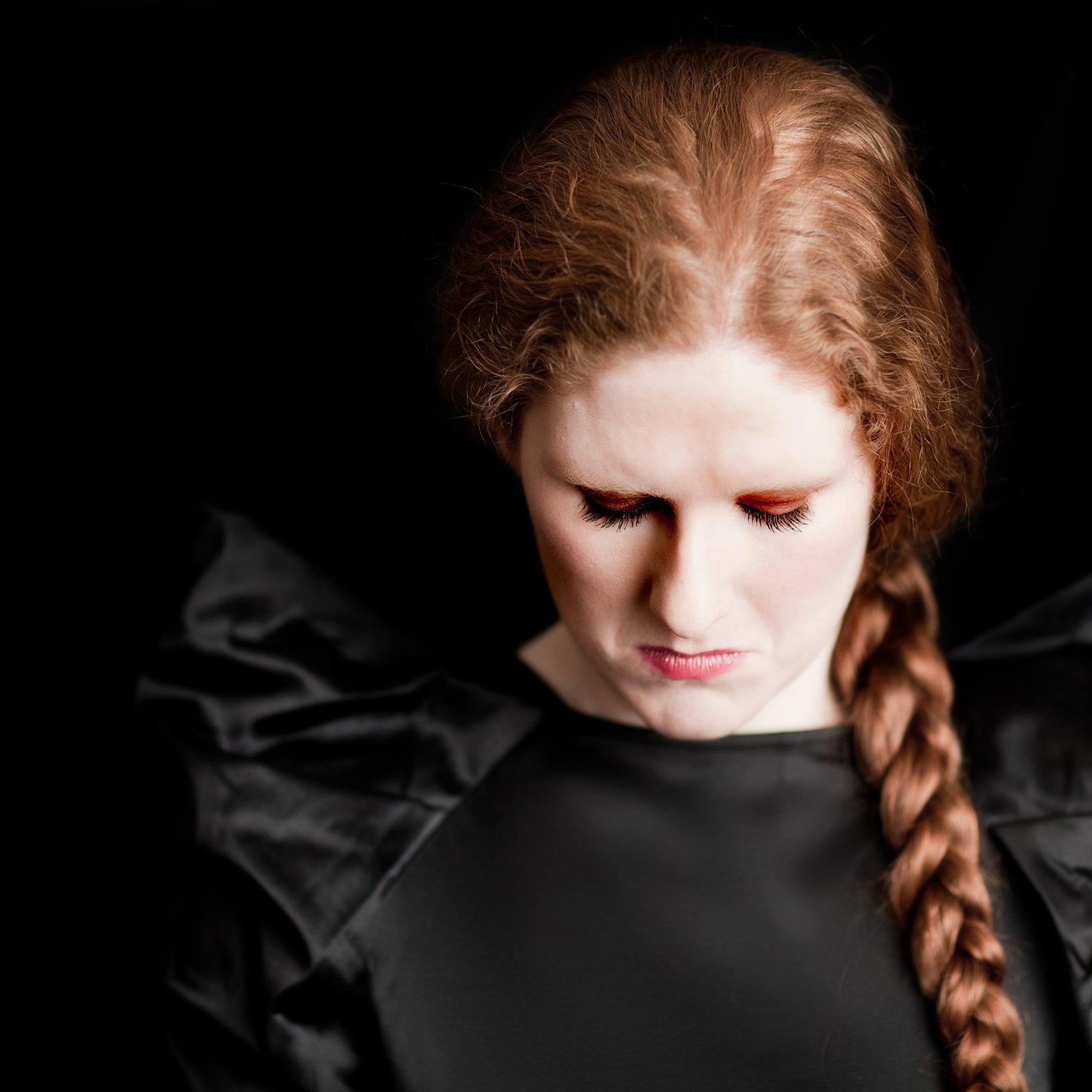 Cheryl Frances-Hoad, composer, looking down with her long red plait over one shoulder, portrait by Mat Smith Photography