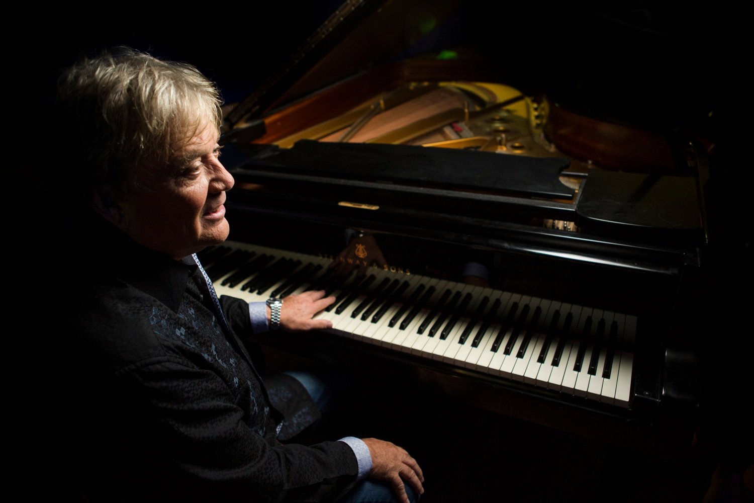 Mike Stock, songwriter and producer, playing a grand piano, portrait by Mat Smith Photography
