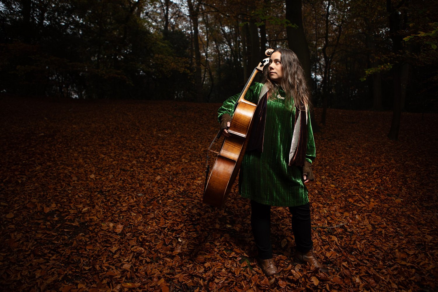 Rebecca Knight, cellist, standing with her cello among autumn leaves, portrait by Mat Smith Photography, Chiltern beech woods, Beaconsfield