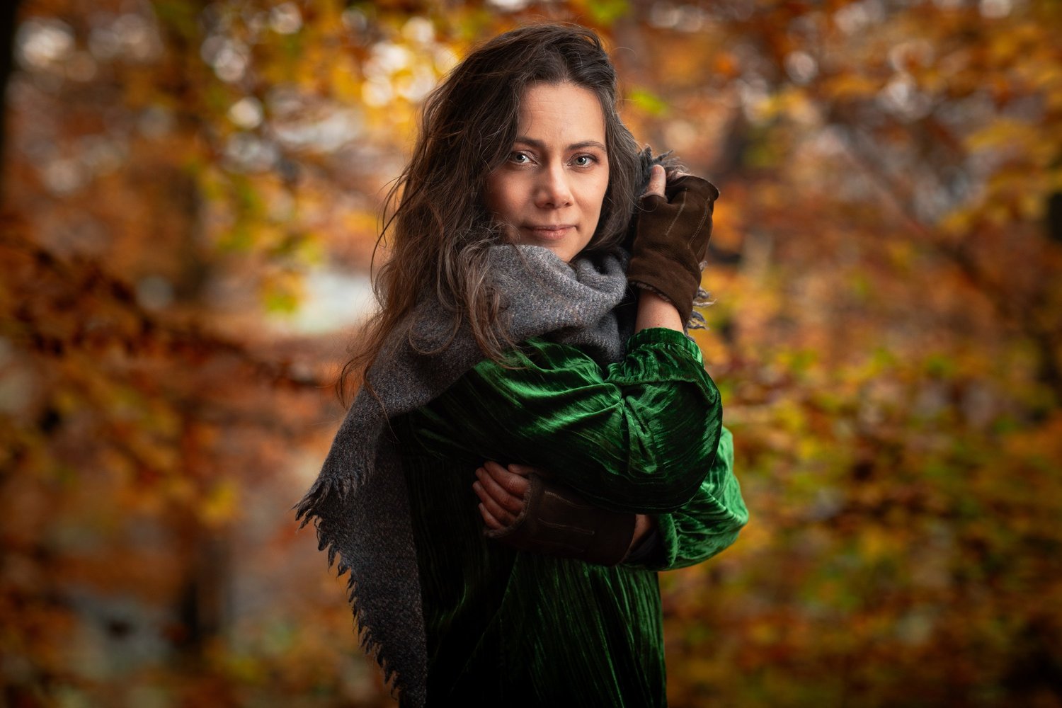 Rebecca Knight, cellist, wrapped in a grey scarf against glowing autumn beech leaves, portrait by Mat Smith Photography, Chiltern beech woods, Beaconsfield