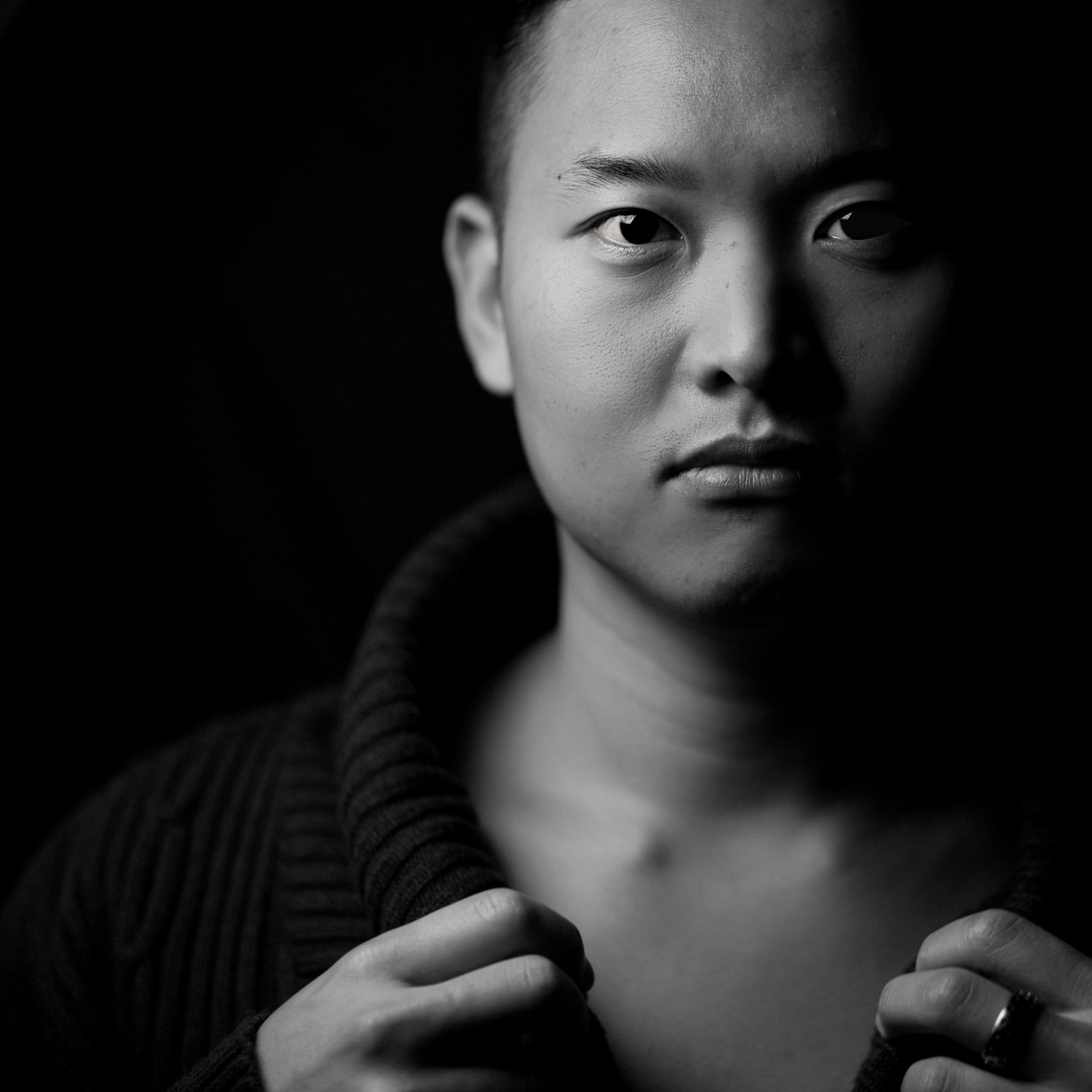 Yoon Chung, classical pianist, in a black and white close portrait holding his collar, portrait by Mat Smith Photography