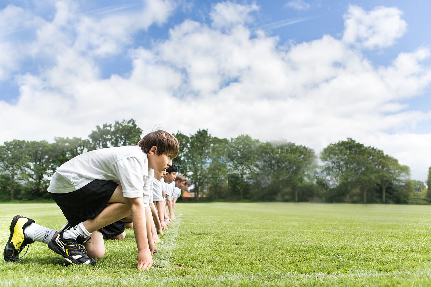 Boys running across the school playing field