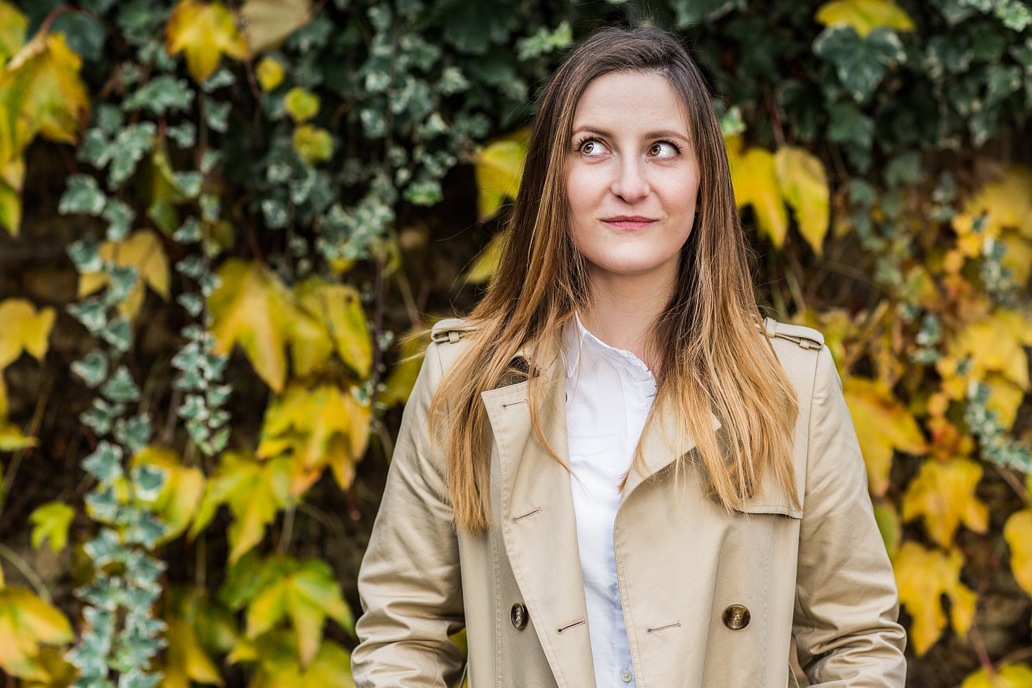 Nell Stevens, author, portrait by Mat Smith Photography among autumn leaves and ivy