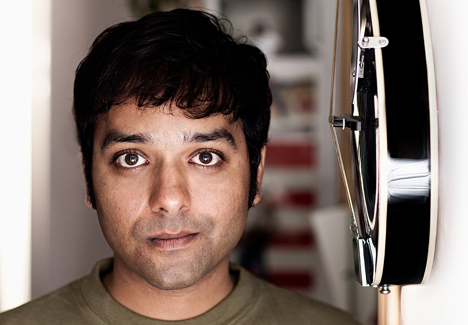 Ajay Srivastav, composer and bandleader, with his black electric guitar, portrait by Mat Smith Photography