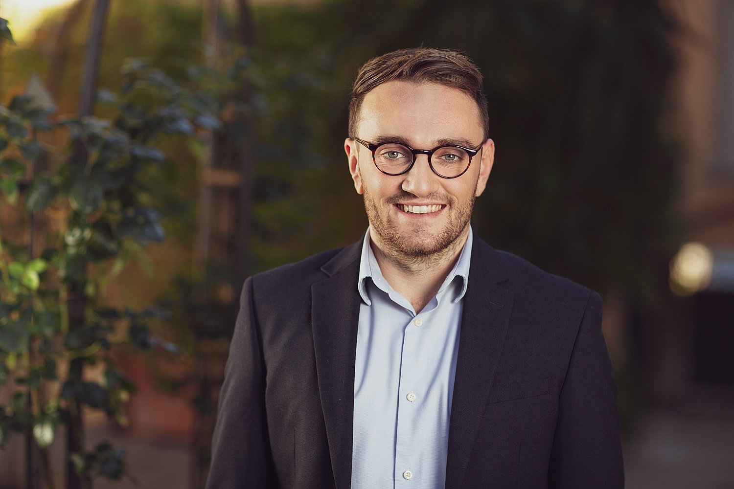 Smiling businessman in a suit and glasses, headshot taken in Italy