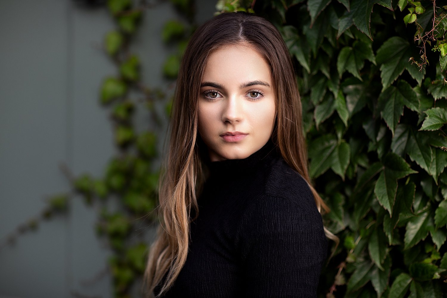 Actor's headshot against ivy, lit by a spotlight