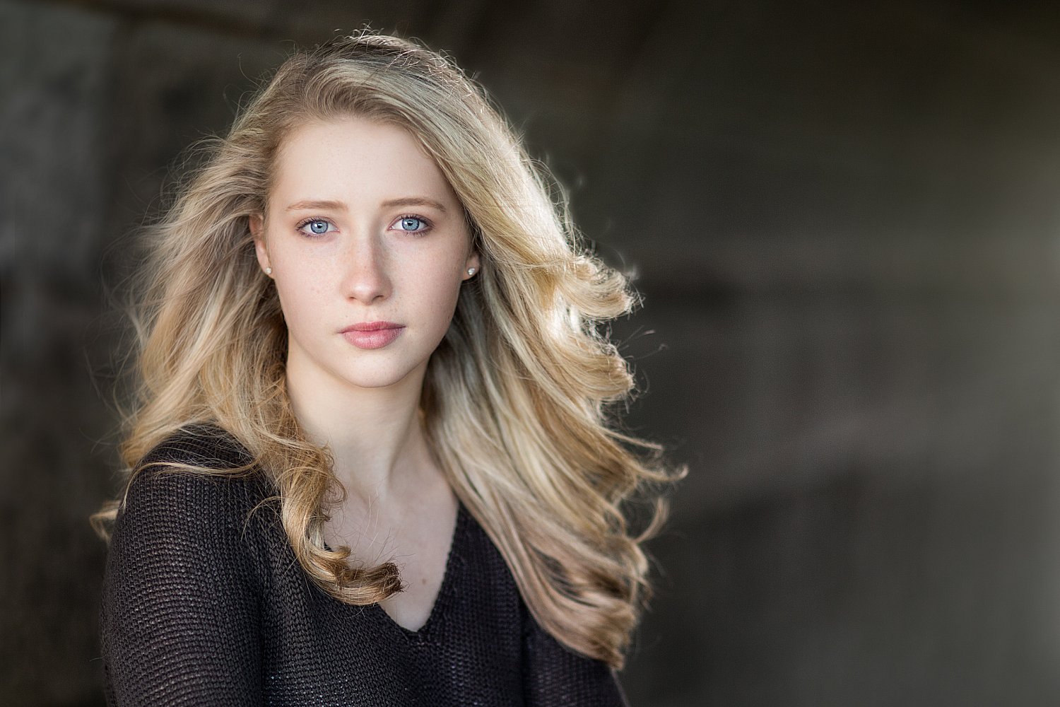 Actor in a windswept tunnel lit by a single spotlight, dramatic portrait